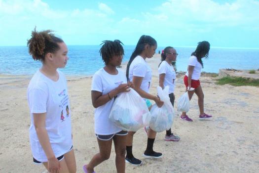 黑人女孩潜水参加了清理的海洋保护努力。