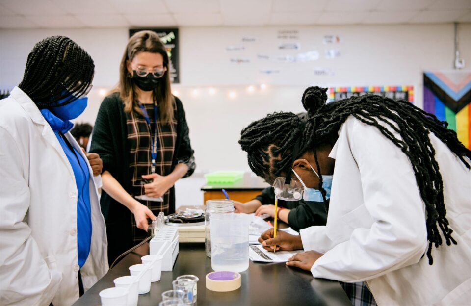 一个科学倡导者协会观察学生们在学校实验室做研究。